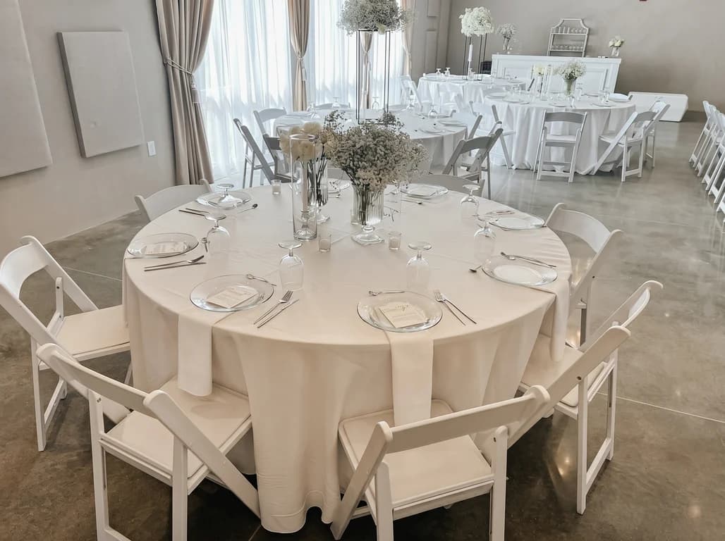 Round table with champagne linens and a tall baby's breath centerpiece set for a reception
